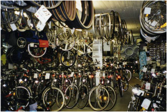Cyklar som finns i butik till försäljning, hänger i taket och står på golvet